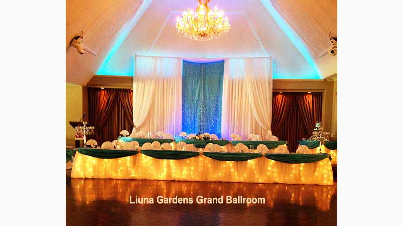 DJ Stoney Creek, Beautiful Head Table Dark Blue & White 2 Levels With White drapery in Back to ceiling Middle drapery is Turquoise With silver beads flowing down. Back lighting is soft white & baby blue Taken in Stoney Creek Ontario